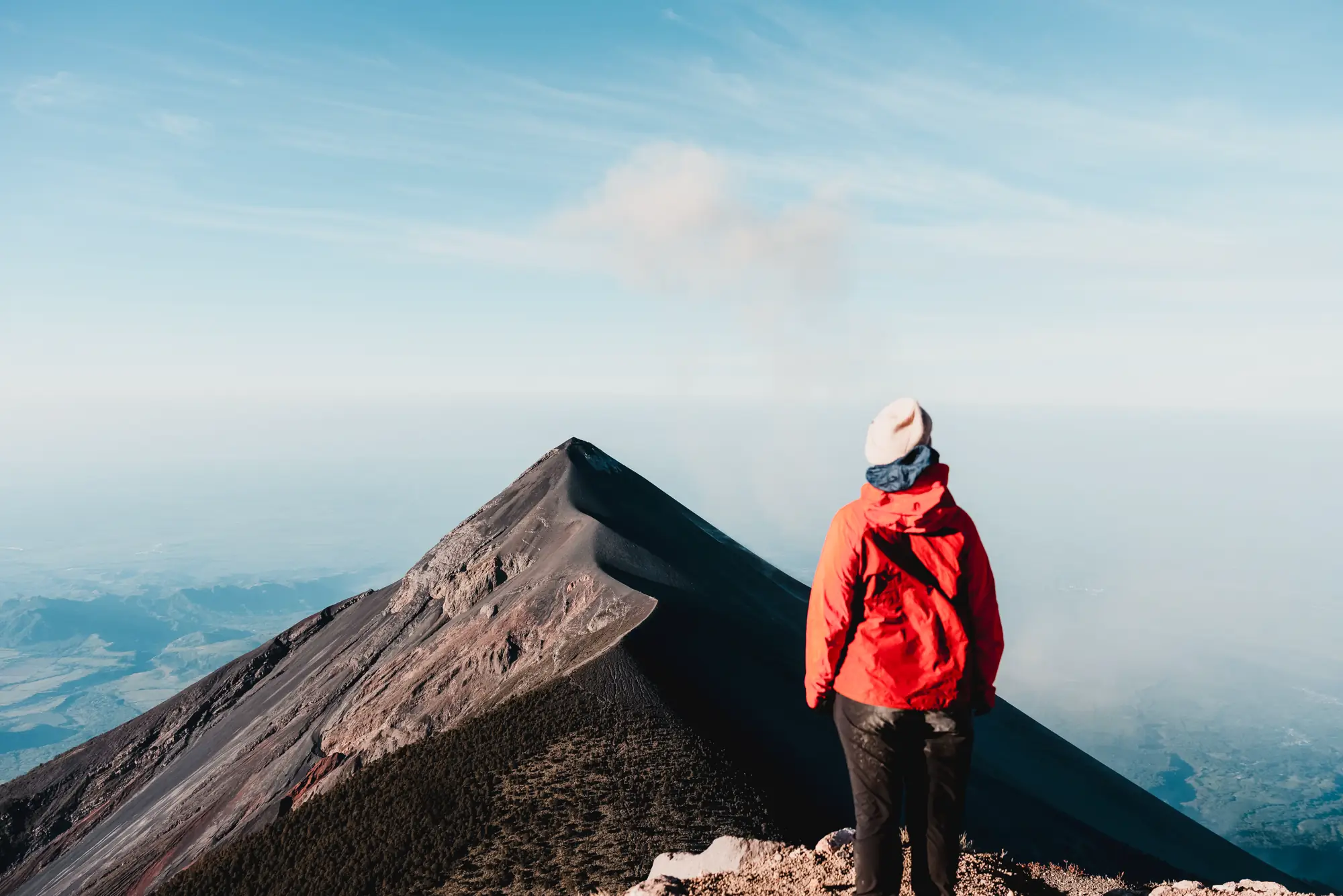 A traveller facing the smoking summit of Volcán de Fuego
