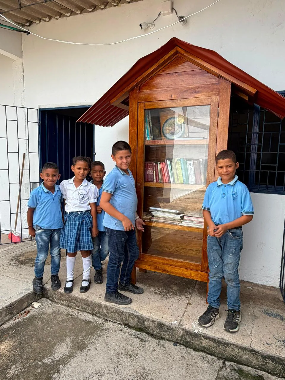 Students beside a community book cabinet