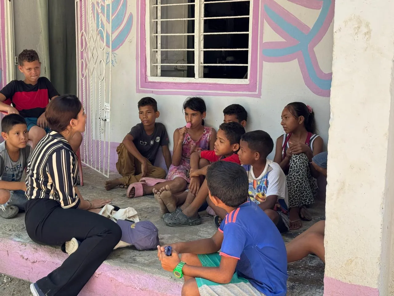A facilitator in conversation with children during an outdoor workshop