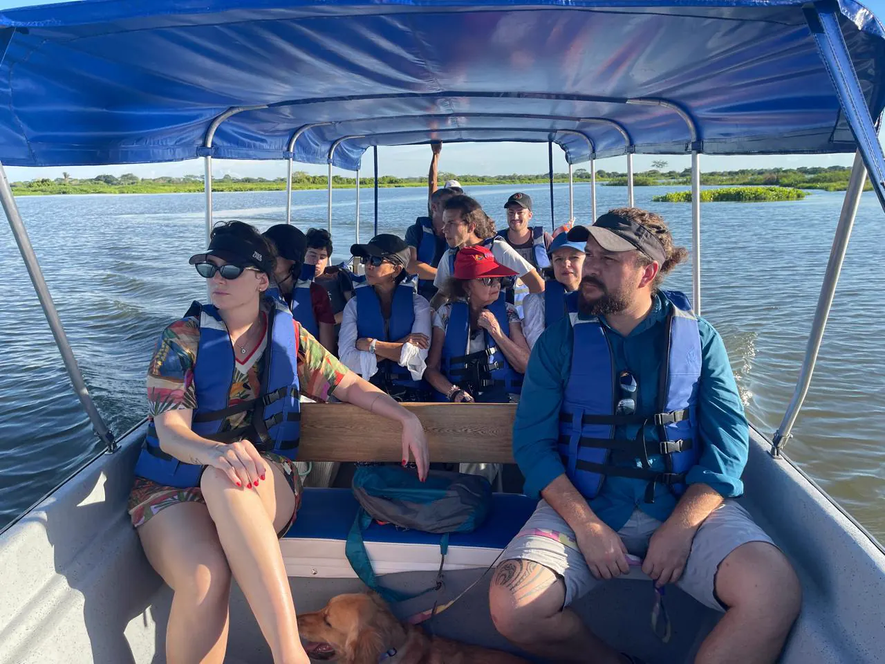 A group travelling the Magdalena River in a boat, wearing life jackets